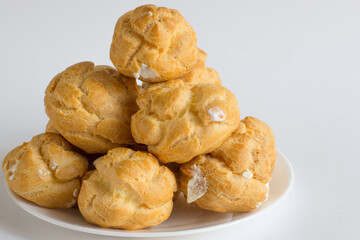 Eclairs on white plate on a whight background. eclairs with cream.