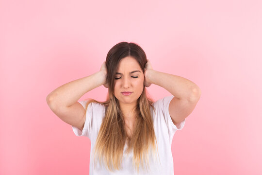 young woman covering her ears. Annoying noise