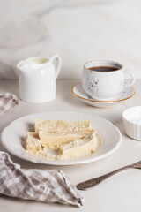 Homemade organic halva is dessert of Turkey. Sliced halva in a plate with coffee.