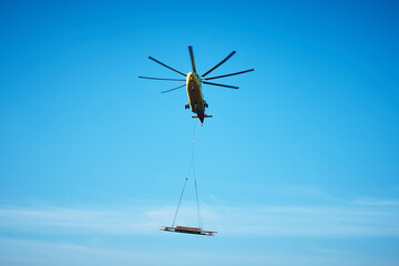 The world's largest cargo helicopter hovers overhead. Bottom view.The world's largest cargo helicopter transports cargo on a wire rope. Bottom view