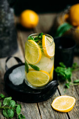 Lemonade with ice and mint in a glass glass on a wooden table