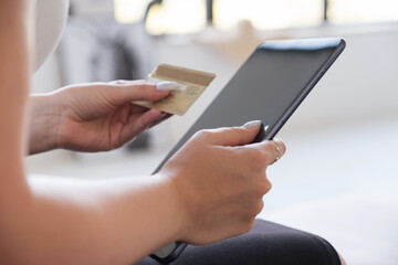Brunette Caucasian woman in white blouse and dark skirt making an order via internet and pay using credit card. Online shopping concept. Space for text