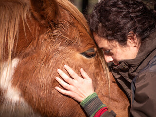 Close up of female forming bond with a piebald pony.
