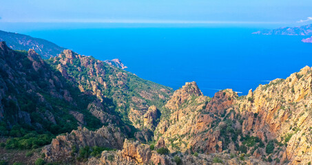 Fototapeta na wymiar Aerial view of beautiful view of sunlit red mountains and the Mediterranean Sea with the Bay of Porto in Calanches area on Corsica island. Tourism and vacaions concept.
