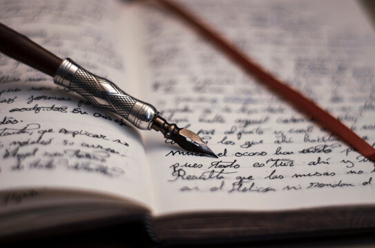 Opened book for beautiful callygraphy. Fountain nib pen writing, handmade black ink