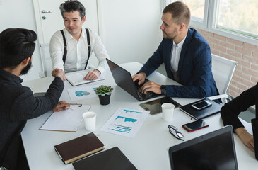 Young business people working and communicating while sitting at the office desk together with colleagues sitting. business meeting