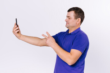 Smiling deaf senior man talking sign language on smartphone camera. White background.