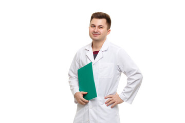 Young handsome doctor in a white coat holding a green folder isolated on a white background.