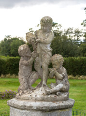 Obraz premium Sculptural composition of three children in the garden 
