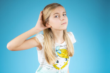 Little girl over isolated background listening to something by putting hand on the ear