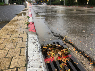 Water gushing from storm sewer following very heavy rainfall of the road after heavy rain. water...