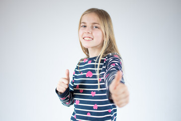 Happy Young girl in striped shirt and showing thumbs up and looking at the camera over white background