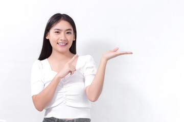 Asian woman in black long hair wears white shirt and shows point up to present something on white background.