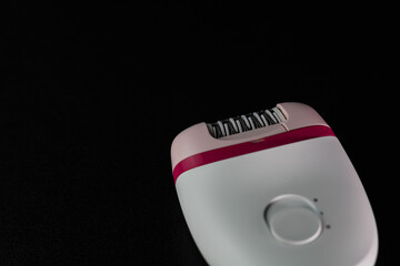 Hair removal concept, electric razor isolated on black background.