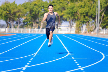 young asian man athlete running and training  on the  track