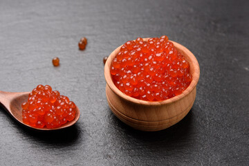 fresh grainy red chum salmon caviar in a wooden spoon, delicious and healthy food