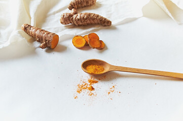Curcumin in a wooden spoon on a white background. Curmin root