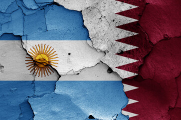 flags of Argentina and Qatar painted on cracked wall