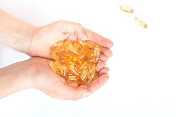 Cod liver oil capsules in hands isolated on white backgrund. Omega 3 pils for healthy heart, cardiovascular system and brain.