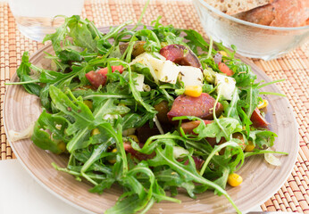 mixed salad of arugula and fresh vegetables with sauce
