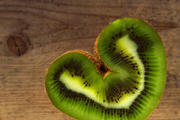 heart sliced kiwi on wooden textured background, healthy and useful food, fresh and juicy heart to Valentines Day