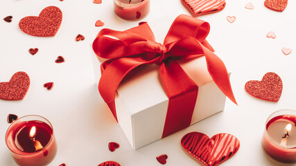 Saint Valentin background: red love hearts, romantic gift box, candle on white table. Romantic...