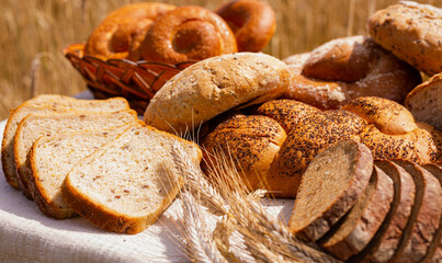 lot of different flavored bread, wheat, rye, on the table in the field outside