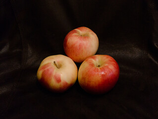 Three apples on a black background. fruits