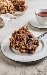 Chocolate cake with caramel cream and peanut on concrete background