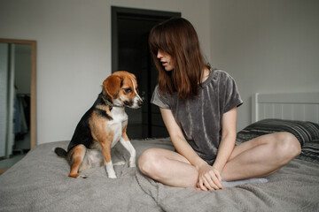 young woman with a dog on the bed in the bedroom