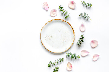 Obraz na płótnie Canvas breakfast plate with petals and eucalyptus on white background top view mockup