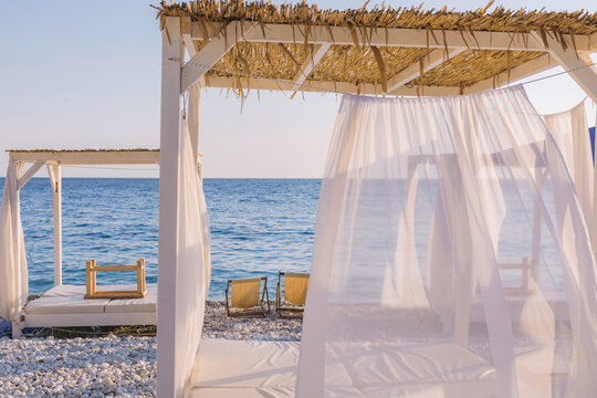 Beautiful canopies or baldachine at sea beach at the sunset. Vacation and relaxation concept.