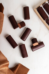 Glazed curds chocolate in a cardboard box on marble background. Dessert chocolate with glazed...