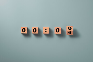 Wooden cube block flipping to change number one to zero on blue background for countdown concept.