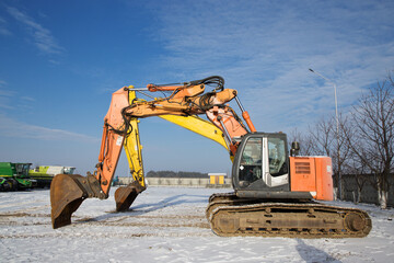 orange and yellow powerful crawler excavators standing on a construction site. Rent, leasing for earthworks