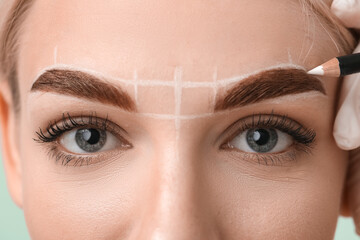 Young woman undergoing eyebrow correction procedure, closeup