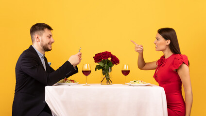 Girlfriend Shouting At Boyfriend While He Using Phone, Yellow Background