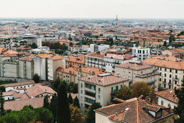 Fototapeta na wymiar Top view of houses, roofs and streets of old Italian city. City panorama, tourism. 