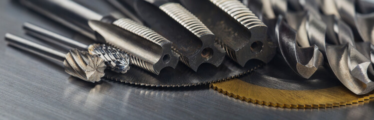 set of different drill bits,thread tap and mill cutters with caliper ruler on steel plate background. Locksmithing deal. © evkaz