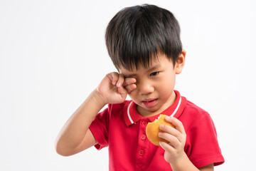 Crying 4 years old Asian boy with cake snack