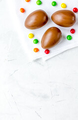Easter chocolate eggs top view on stone background mock up