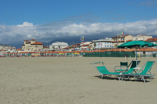 View Of The Beach, Empty Green Beach Chairs And Umbrella