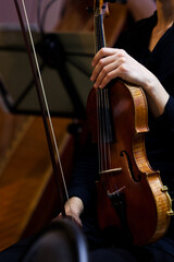 Violin in the hands of a musician in the orchestra close up