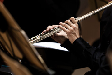 Hands of a musician playing the flute close up