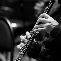Hands of a musician playing the oboe close-up in black and white