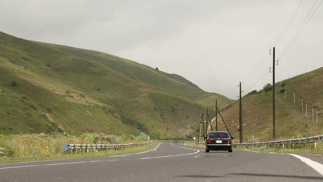 Sevan, Armenia - August 2019 - Cars rides on a paved smooth road in the middle of a mountainous area 