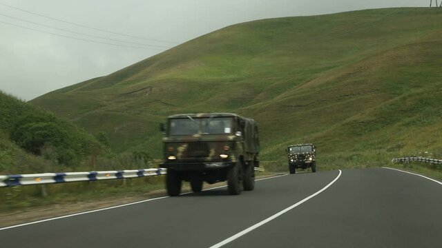Sevan, Armenia - August 2019 - Military trucks rides on a paved smooth road in the middle of a mountainous area