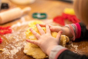 Close up of the hand of a two year old girl helping to prepare the pastry.