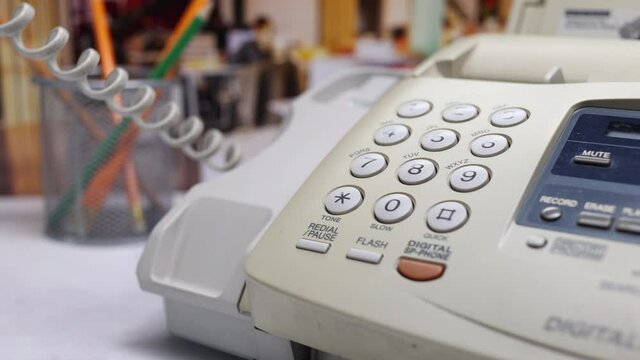 Man Dialing 911 On The Number Buttons On The Old Fax Telephone. A Man's Hand Picks Up The Phone And Dials A Phone Number 911 On The White Keyboard Of A Landline In The Office.