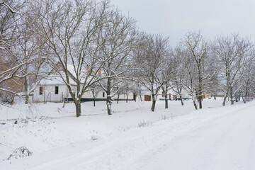 Fototapeta na wymiar Traditional houses in small village during heavy snow fall (Bakonyszucs, Hungary)